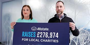 ANI employees hold up a sign stating Allstate raises £276,974 for local charities.  