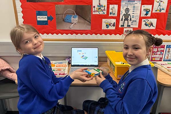 Young girls work together in making a lego taxi.