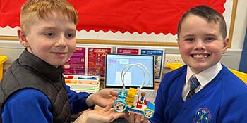 Young boys work together in making a lego taxi. 