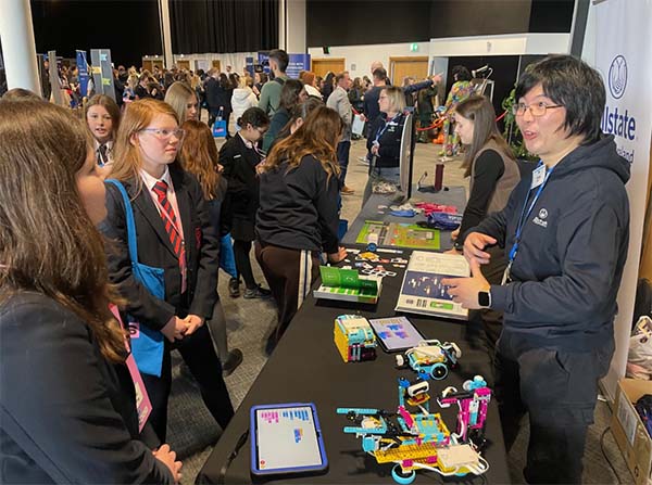 Girls interacting with representatives from Allstate NI at ANI's booth for the Empower Girls 2026 event. 