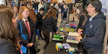 Girls interacting with representatives from Allstate NI at ANI's booth for the Empower Girls 2026 event. 