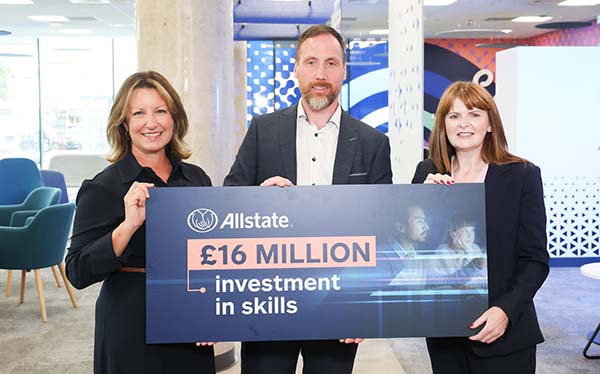 Allstate NI employees hold a large board that states Allstate £16m investment in skills. 