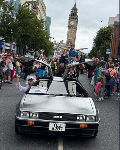 ANI employees driving a DeLoren in the Belfast Pride parade. 